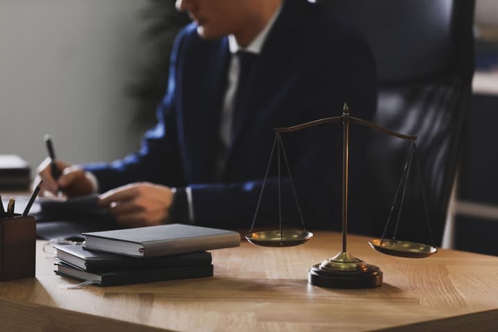 Lawyer working at desk with scales of justice and legal books