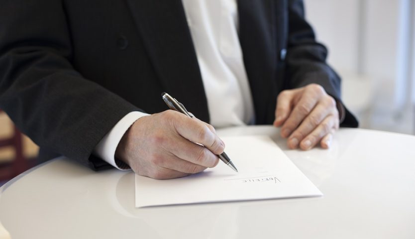 person-with-pen-signing-contract