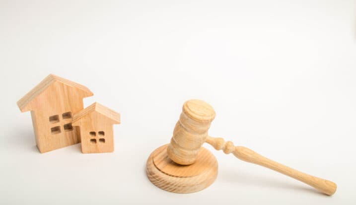 Wooden gavel beside small model houses representing property dispute