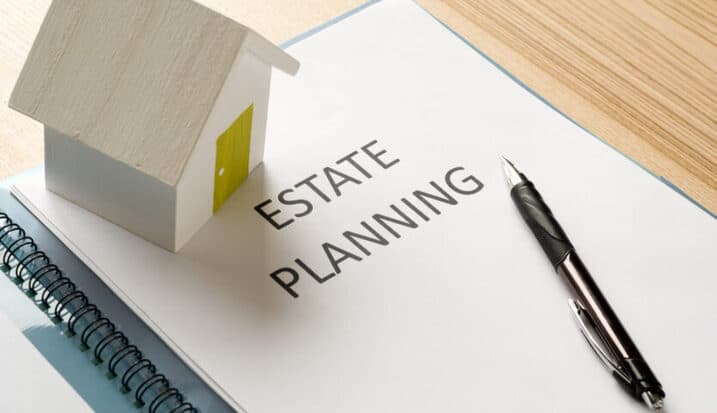 Estate planning document with pen and small model house on desk