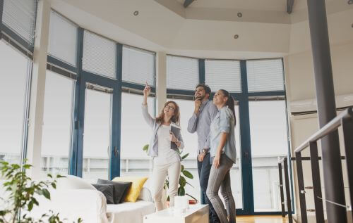 Real estate agent showing a modern condo to a couple.