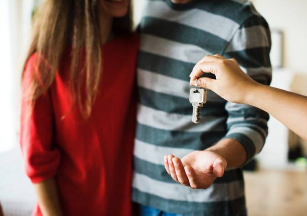 Couple receiving house keys during home purchase.