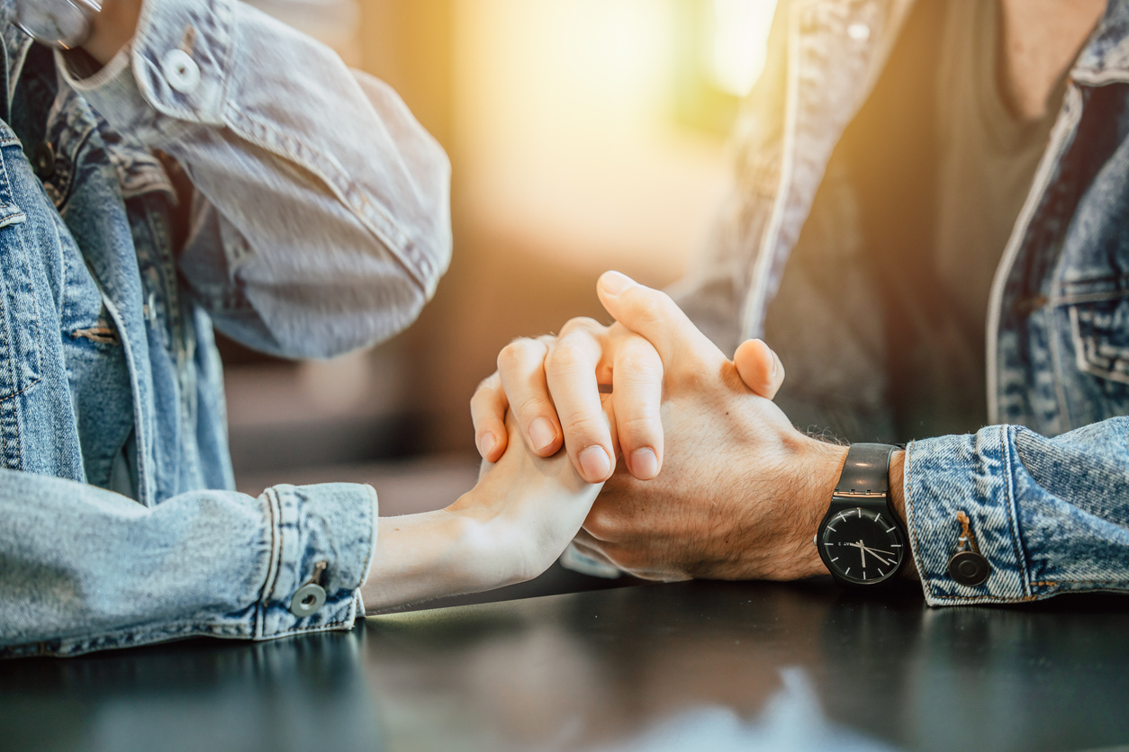 Unmarried couple holding hands while discussing a cohabitation agreement and future legal planning in Edmonton